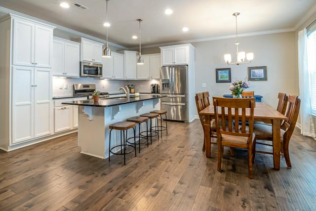 a clean kitchen with stainless steel appliances and a wooden dining table